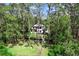 Aerial view of a two-story home nestled among tall trees with a path leading to the waterfront at 13562 S Lake Mary Jane Rd, Orlando, FL 32832
