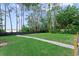 Lush backyard with a walkway leading to serene water views, surrounded by mature trees at 13562 S Lake Mary Jane Rd, Orlando, FL 32832