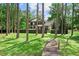 Beautiful backyard with a glimpse of the modern home, framed by tall trees and greenery at 13562 S Lake Mary Jane Rd, Orlando, FL 32832