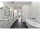 Bright bathroom featuring a soaking tub, double sink vanity with marble countertops, and sleek black hardware at 13562 S Lake Mary Jane Rd, Orlando, FL 32832