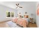 Charming bedroom with two twin beds, neutral walls, a ceiling fan, and natural light from a large window at 13562 S Lake Mary Jane Rd, Orlando, FL 32832