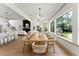 Spacious dining area with view of kitchen and fireplace, a wooden table, and large windows overlooking yard at 13562 S Lake Mary Jane Rd, Orlando, FL 32832
