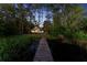 Long dock leading to a lake behind the home, surrounded by natural landscaping and mature trees at 13562 S Lake Mary Jane Rd, Orlando, FL 32832