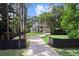 Long driveway with a gated entrance leading to a beautiful two-story home surrounded by trees at 13562 S Lake Mary Jane Rd, Orlando, FL 32832