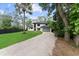 Two-story home boasts a modern elevation with a gray garage door, and a gravel driveway nestled among mature trees at 13562 S Lake Mary Jane Rd, Orlando, FL 32832