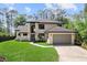 Charming two-story home featuring a well-manicured front lawn, modern exterior, and attached gray garage door at 13562 S Lake Mary Jane Rd, Orlando, FL 32832