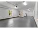 Finished garage showcasing a clean, functional space with a utility door, water heater, gray epoxy floors, and bright lighting at 13562 S Lake Mary Jane Rd, Orlando, FL 32832