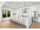 Modern kitchen with a large center island with seating, pendant lighting, and stainless steel appliances at 13562 S Lake Mary Jane Rd, Orlando, FL 32832
