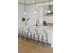 Modern kitchen island with seating and pendant lights, complemented by sleek white cabinetry and countertops at 13562 S Lake Mary Jane Rd, Orlando, FL 32832