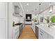 Modern kitchen features white cabinets, stainless steel appliances, and a view into the living room at 13562 S Lake Mary Jane Rd, Orlando, FL 32832