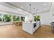 Open kitchen features a center island, stainless steel appliances, modern lighting and a large window at 13562 S Lake Mary Jane Rd, Orlando, FL 32832