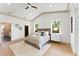 Bright main bedroom featuring tray ceilings, wood floors, two windows, and an en suite bath at 13562 S Lake Mary Jane Rd, Orlando, FL 32832