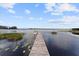 Scenic view of a serene lake with a wooden dock extending into the calm water at 13562 S Lake Mary Jane Rd, Orlando, FL 32832