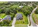 Aerial view of a home with a lush, green lawn, mature trees, and a private driveway at 16500 Magnolia Terrace Blvd, Montverde, FL 34756