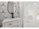 Stylish bathroom vanity with quartz countertop, geometric mirror and faucet, next to doorway at 16500 Magnolia Terrace Blvd, Montverde, FL 34756