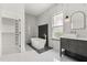 Modern bathroom featuring a freestanding tub with gold fixtures and stylish black and white tiling at 16500 Magnolia Terrace Blvd, Montverde, FL 34756