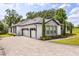 Beautiful home with an oversized three-car garage, stone accents, and lush landscaping at 16500 Magnolia Terrace Blvd, Montverde, FL 34756