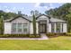 Charming single-story home with stone accents, manicured landscaping, and a modern glass front door at 16500 Magnolia Terrace Blvd, Montverde, FL 34756