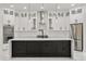Modern kitchen featuring white cabinets, herringbone backsplash, a large black island, and stainless steel appliances at 16500 Magnolia Terrace Blvd, Montverde, FL 34756