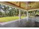 Expansive covered patio with wood ceilings, ceiling fans, and a beautiful view of the lush backyard at 16500 Magnolia Terrace Blvd, Montverde, FL 34756