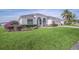 Beautiful single-story home with manicured lawn, arched entry, and lush landscaping with ample curb appeal at 409 Belfry Dr, Davenport, FL 33897