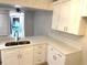 Renovated kitchen with bright white cabinetry, stone countertops, and stainless faucet at 604 Kenwick Cir # 105, Casselberry, FL 32707