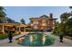 Gorgeous backyard with a brick home, a covered outdoor kitchen, pool and lush landscaping at 690 E Church St, Bartow, FL 33830