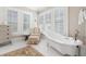 Bright bathroom showcasing a luxurious clawfoot tub beneath shuttered windows at 690 E Church St, Bartow, FL 33830