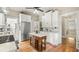 Charming kitchen with white cabinetry, an island with marble countertop, and stainless steel appliances at 690 E Church St, Bartow, FL 33830