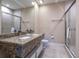 Bathroom featuring granite double vanity and glass shower enclosure at 7672 Amazonas St, Kissimmee, FL 34747