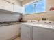 Bright laundry room with washer, dryer, and ample counter space with a sink at 7672 Amazonas St, Kissimmee, FL 34747