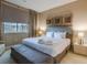 Inviting main bedroom with a king bed, bench, and soft, neutral decor at 7672 Amazonas St, Kissimmee, FL 34747