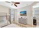 Charming bedroom with a bunk bed and single bed, plus a TV and views into the hallway at 8044 Lost Shaker Ln, Kissimmee, FL 34747