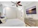 Bedroom featuring a ceiling fan, mounted TV, and a bed with decorative pillows at 8044 Lost Shaker Ln, Kissimmee, FL 34747