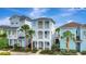 Stunning three-story home with double balconies, surrounded by lush landscaping and blue skies at 8044 Lost Shaker Ln, Kissimmee, FL 34747