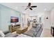 Bright living room featuring modern furniture, a ceiling fan, and an open floor plan to the kitchen at 8044 Lost Shaker Ln, Kissimmee, FL 34747