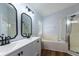 Bright bathroom with double sinks, modern fixtures, a soaking tub, and a glass-enclosed shower at 830 Grand Hughey Ct, Apopka, FL 32712