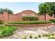 Brick community entrance with floral accents shows well-maintained landscaping at 830 Grand Hughey Ct, Apopka, FL 32712