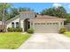 Well-maintained single-story home with manicured lawn and attached two-car garage at 830 Grand Hughey Ct, Apopka, FL 32712