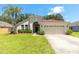 Charming single-story home featuring a well-manicured lawn and attached two-car garage at 830 Grand Hughey Ct, Apopka, FL 32712
