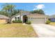 Well maintained single-story home with an attached two-car garage and mature landscaping at 830 Grand Hughey Ct, Apopka, FL 32712