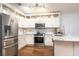 Modern kitchen with stainless steel appliances, white cabinetry, and marble countertops at 830 Grand Hughey Ct, Apopka, FL 32712