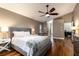 Comfortable main bedroom featuring a ceiling fan, wood floors, and a view leading into the main bathroom at 830 Grand Hughey Ct, Apopka, FL 32712