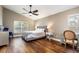 Serene main bedroom featuring hardwood floors, natural light, and ceiling fan at 830 Grand Hughey Ct, Apopka, FL 32712