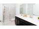 Bathroom with dual sinks, white countertop, black cabinets, and glass shower door with marble tile at 9312 Sommerset Hills Dr, Davenport, FL 33896