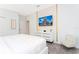 Bright bedroom featuring light gray walls, white furniture, and a TV showcasing a Disney castle at 9312 Sommerset Hills Dr, Davenport, FL 33896
