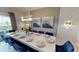 Elegant dining room with a long table set for a formal meal, lit by a modern chandelier at 9312 Sommerset Hills Dr, Davenport, FL 33896