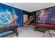 A bright game room with Disney themed walls featuring a pool table, foosball table, and a basketball arcade game at 9312 Sommerset Hills Dr, Davenport, FL 33896
