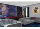 Spacious game room with foosball, pool table, video games, modern sofa, and custom themed wall art at 9312 Sommerset Hills Dr, Davenport, FL 33896