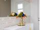 Close-up on a white cabinet with artistic flower decor and a geometric mirror at 9312 Sommerset Hills Dr, Davenport, FL 33896